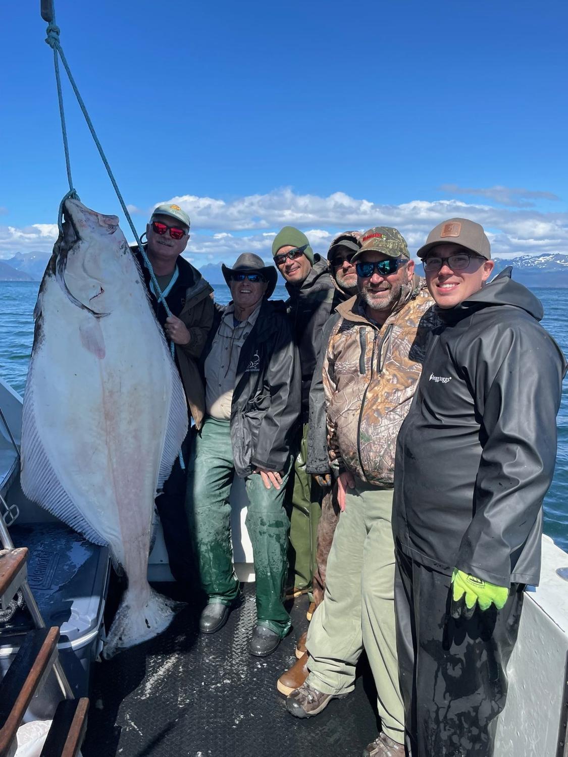 Guests with an Alaskan halibut aboard Swoboda Charters