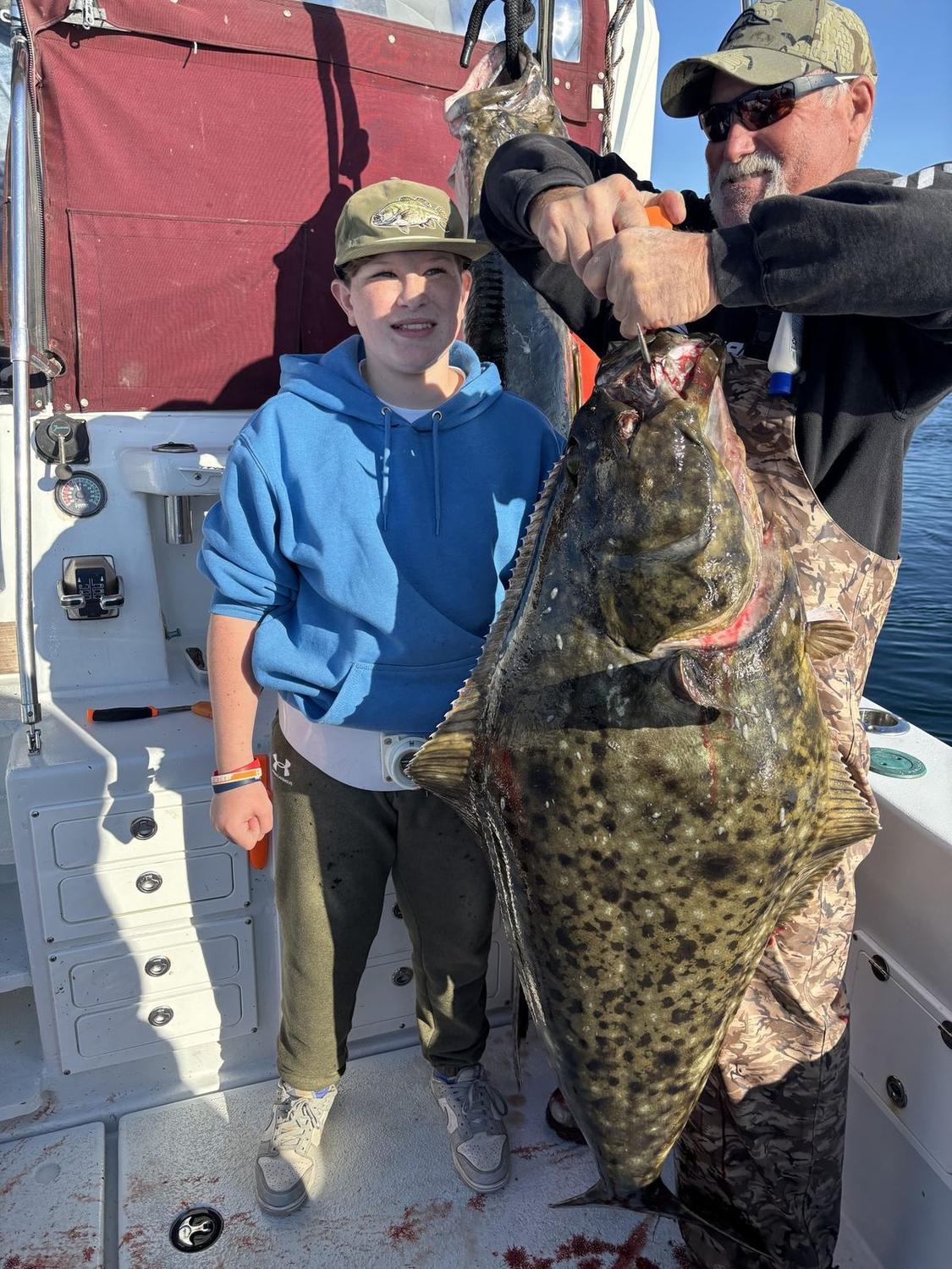 Young angler and captain with a big Alaskan halibut
